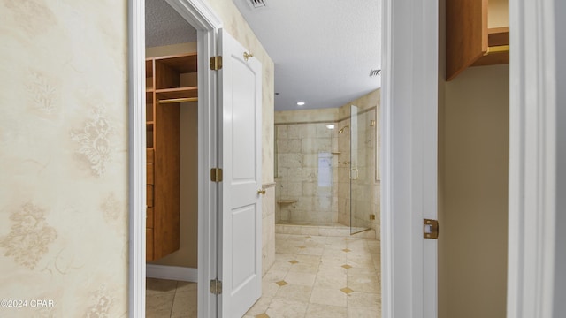 bathroom with a textured ceiling and walk in shower