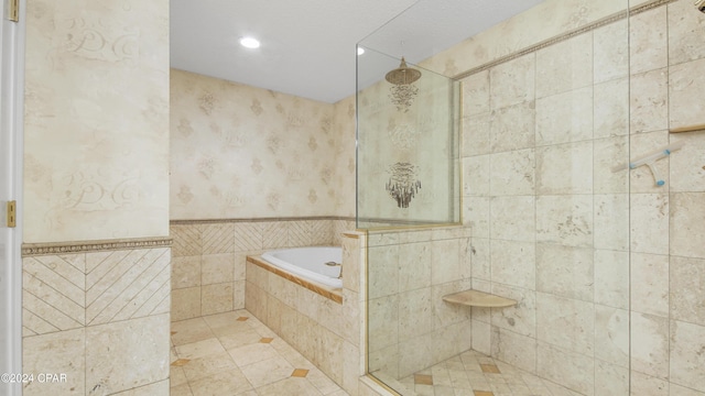 bathroom featuring tile patterned flooring, tile walls, and independent shower and bath