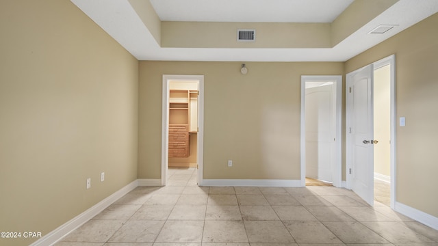 unfurnished bedroom featuring a walk in closet and a closet