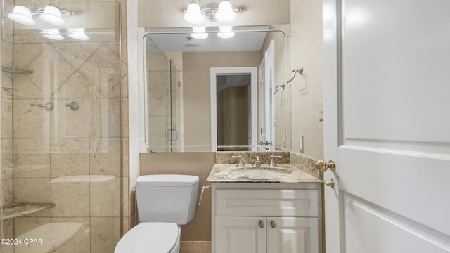 bathroom featuring vanity, toilet, and a shower with door