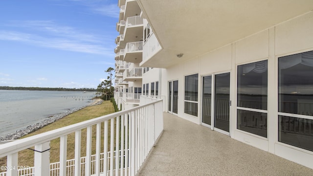 balcony with a water view and a view of the beach