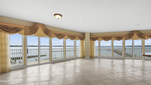 unfurnished sunroom with a water view