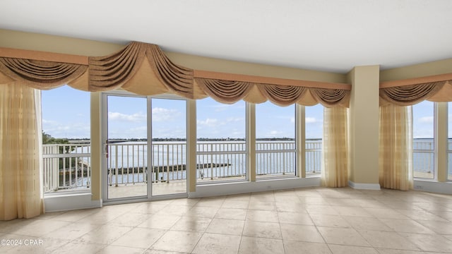 unfurnished sunroom with plenty of natural light and a water view