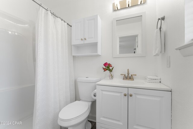 bathroom with walk in shower, vanity, and toilet