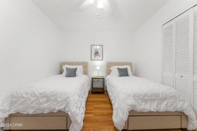 bedroom with ceiling fan, a closet, and wood-type flooring