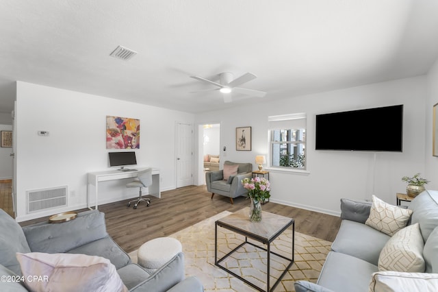 living room with baseboards, ceiling fan, wood finished floors, and visible vents