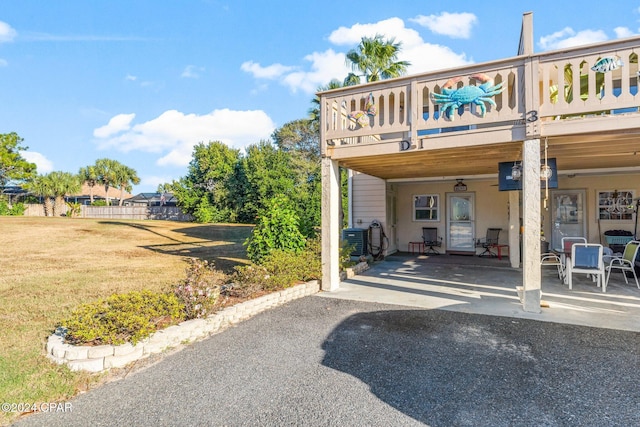 exterior space with a patio, a balcony, central AC, and a lawn