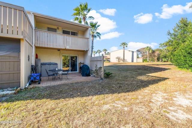 back of house with a yard, a patio, and a balcony