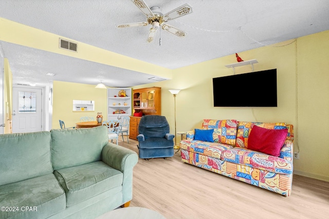 living room featuring a textured ceiling, hardwood / wood-style flooring, and ceiling fan