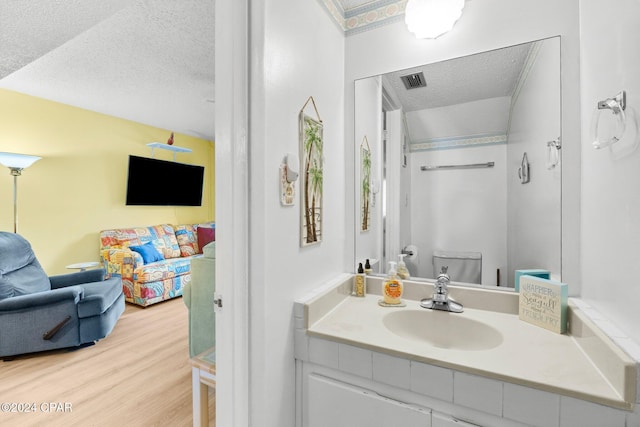 bathroom featuring toilet, vanity, a textured ceiling, and hardwood / wood-style flooring