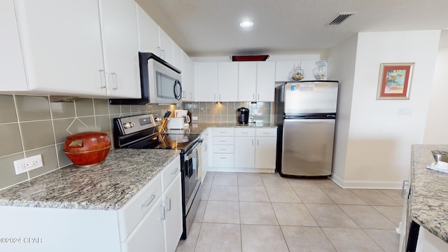 kitchen with white cabinetry, light stone countertops, stainless steel appliances, tasteful backsplash, and light tile patterned floors