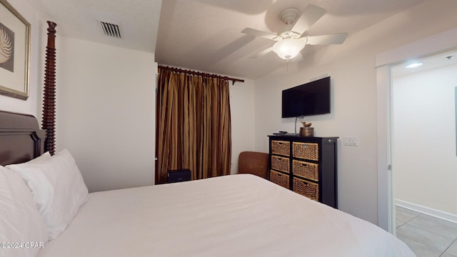 bedroom with ceiling fan and light tile patterned floors