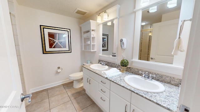 bathroom with tile patterned flooring, vanity, toilet, and walk in shower