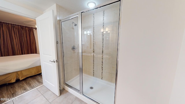 bathroom with tile patterned flooring and a shower with door