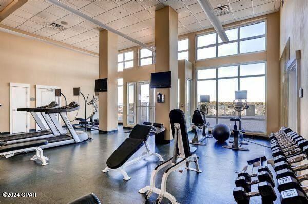 exercise room with a drop ceiling and a towering ceiling