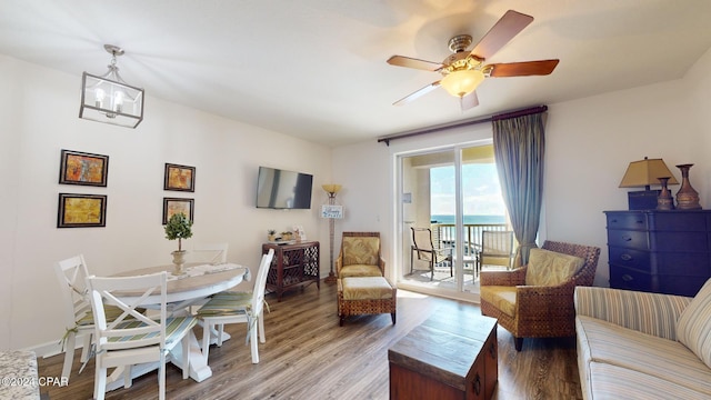 living room with hardwood / wood-style flooring and ceiling fan with notable chandelier