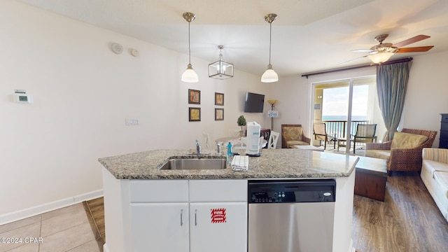 kitchen featuring sink, stainless steel dishwasher, decorative light fixtures, white cabinetry, and wood-type flooring