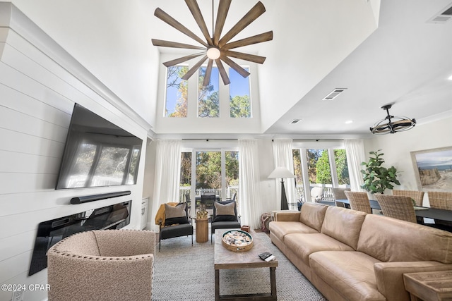 living room featuring a towering ceiling and a chandelier