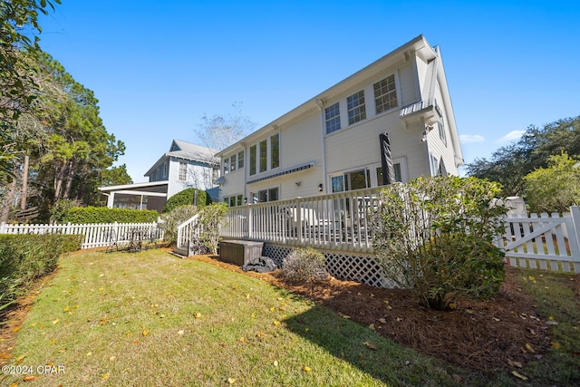 back of property featuring a yard and a wooden deck