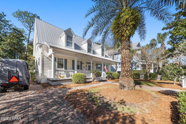 cape cod-style house featuring covered porch