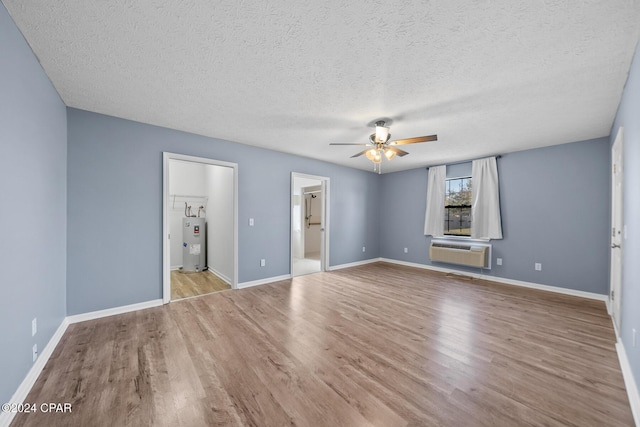 unfurnished bedroom with connected bathroom, ceiling fan, a wall mounted air conditioner, electric water heater, and light hardwood / wood-style flooring