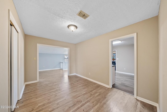 interior space with light hardwood / wood-style flooring and a textured ceiling