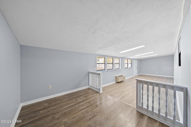 empty room featuring a textured ceiling and light hardwood / wood-style floors