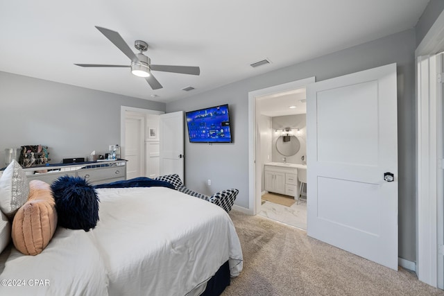 bedroom featuring visible vents, ensuite bathroom, light carpet, ceiling fan, and baseboards