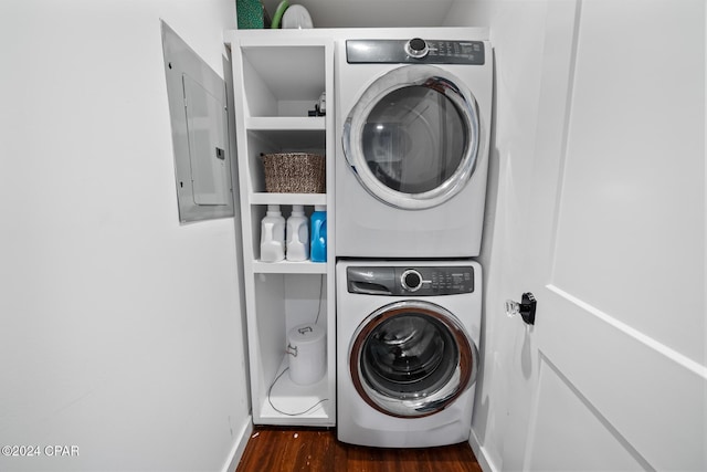 washroom with laundry area, stacked washing maching and dryer, wood finished floors, and electric panel