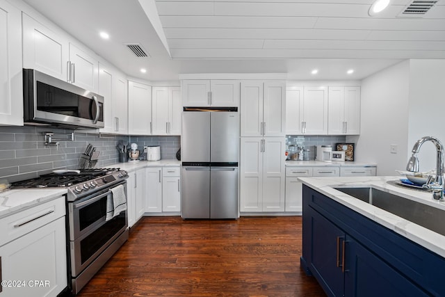 kitchen with dark wood-style floors, visible vents, appliances with stainless steel finishes, white cabinets, and a sink