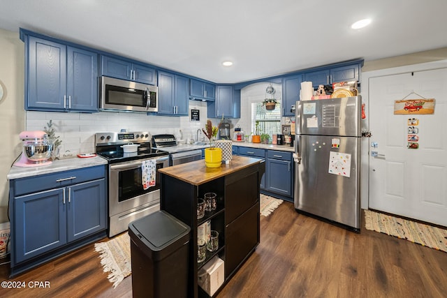 kitchen with stainless steel appliances, blue cabinetry, and dark wood-style floors