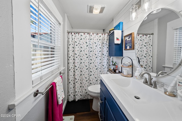 full bath with tile walls, visible vents, toilet, vanity, and wood finished floors