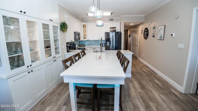 dining area with hardwood / wood-style flooring, ornamental molding, and sink