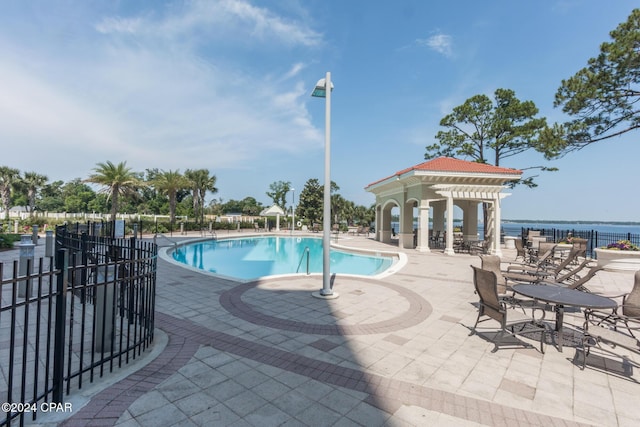 view of pool with a gazebo, a water view, and a patio