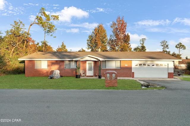 ranch-style home with a garage and a front lawn