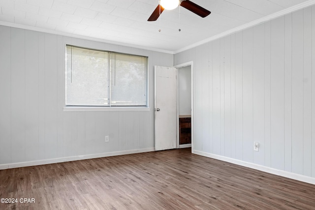 empty room featuring hardwood / wood-style flooring, ceiling fan, and ornamental molding