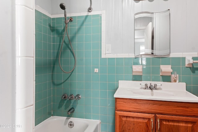 bathroom with vanity, tiled shower / bath, and tile walls