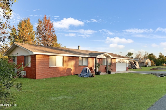 ranch-style house featuring a front yard and a garage