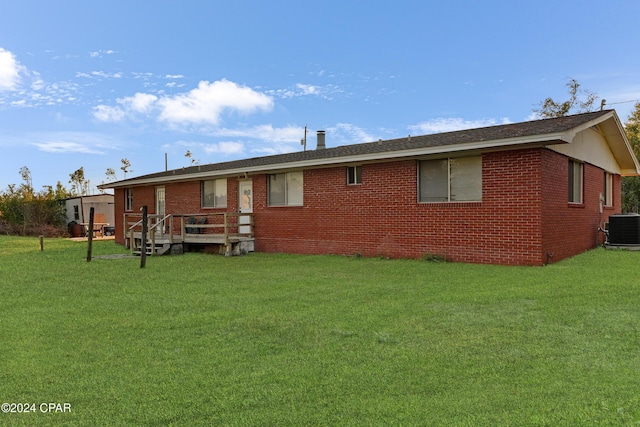 rear view of house with a lawn and central air condition unit