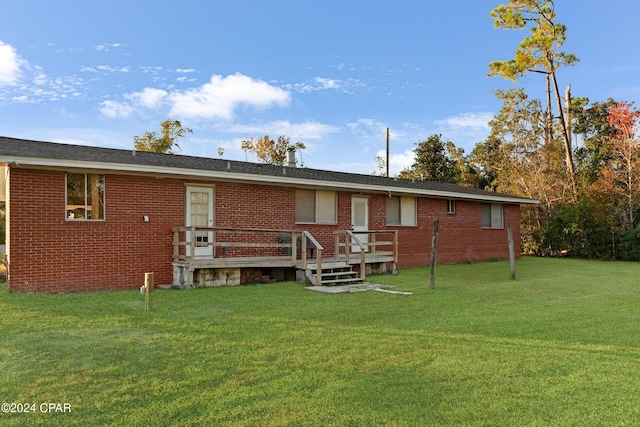 rear view of property featuring a lawn and a wooden deck