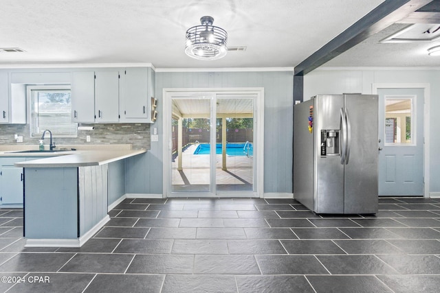 kitchen with decorative backsplash, stainless steel fridge, sink, and plenty of natural light