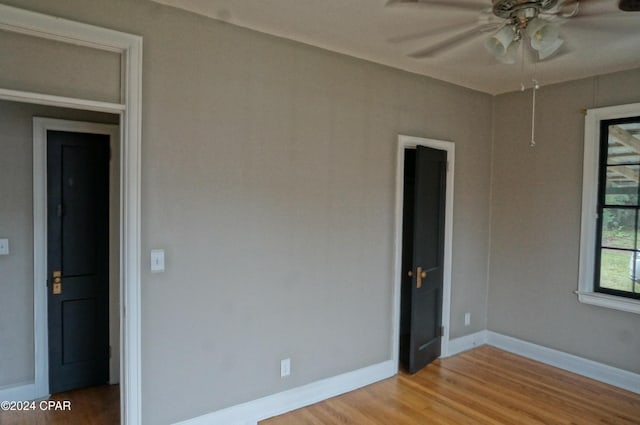 empty room with ceiling fan and light hardwood / wood-style flooring