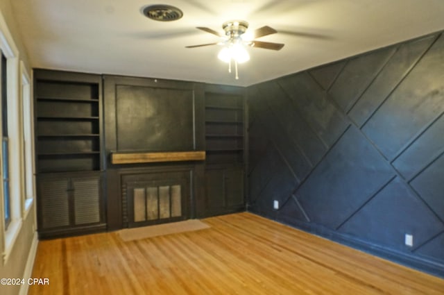 unfurnished living room with hardwood / wood-style flooring and ceiling fan