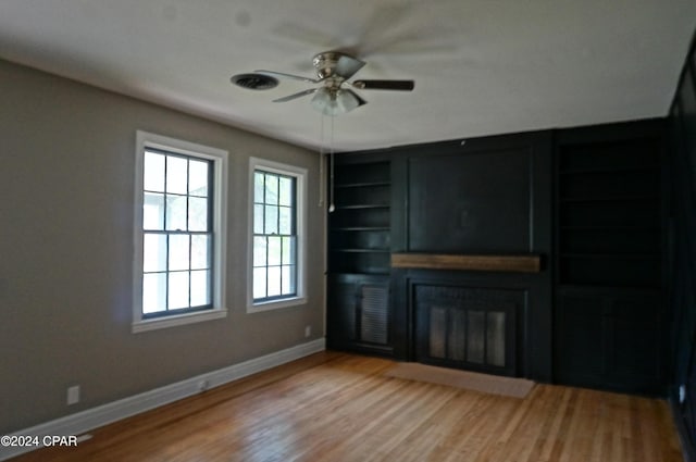 unfurnished living room with ceiling fan, light hardwood / wood-style flooring, and built in features