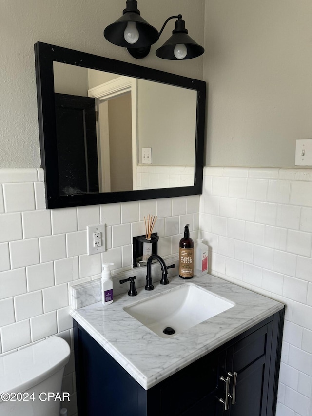 bathroom with vanity, toilet, tile walls, and backsplash