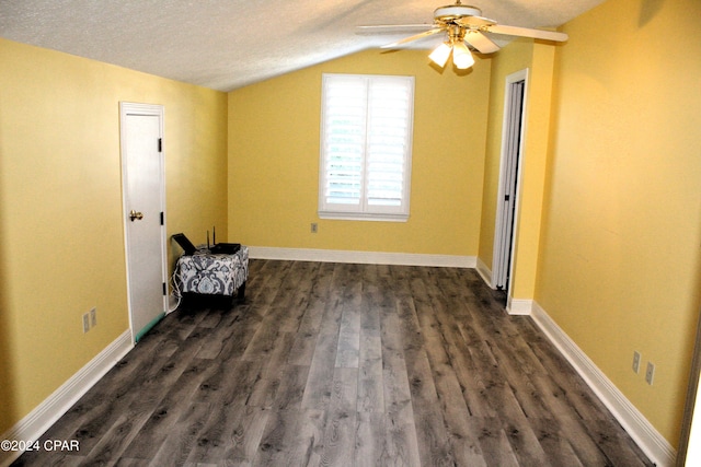 additional living space featuring dark hardwood / wood-style floors, ceiling fan, lofted ceiling, and a textured ceiling