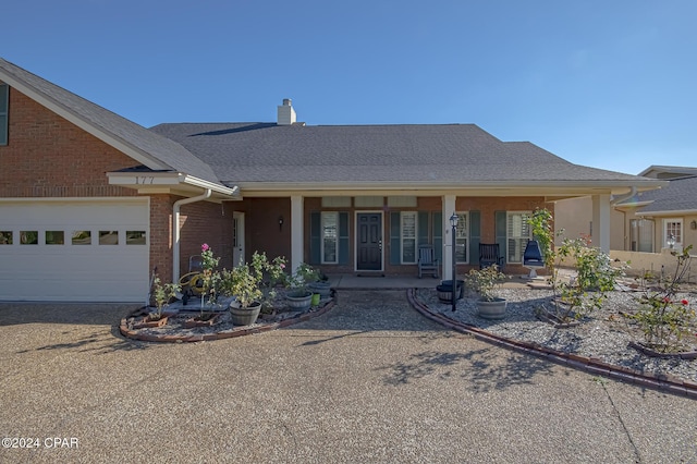 single story home featuring a porch and a garage