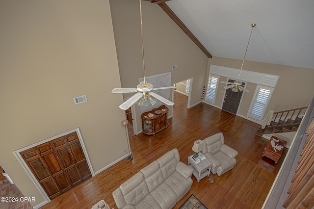 living room with ceiling fan, hardwood / wood-style floors, high vaulted ceiling, and beamed ceiling