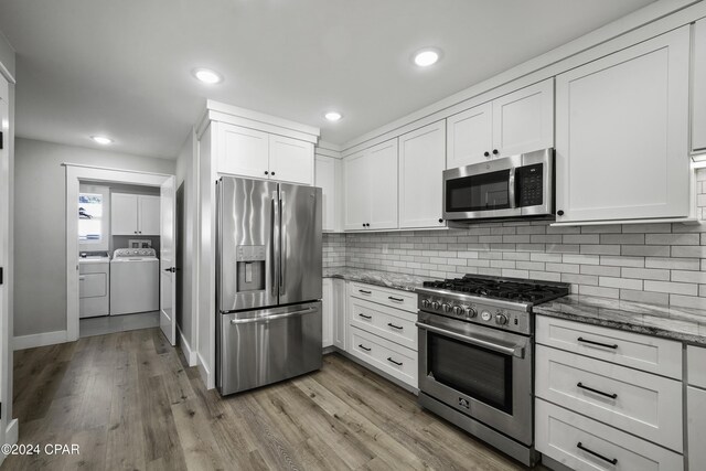 kitchen with white cabinetry, stainless steel appliances, stone countertops, and light wood-type flooring