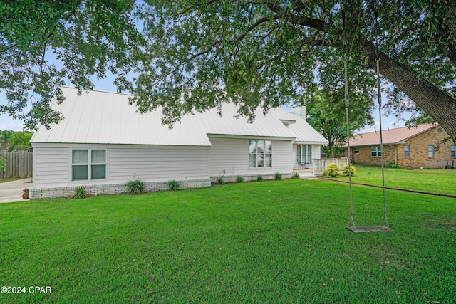 rear view of property featuring a lawn and a deck